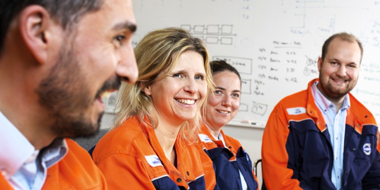 Team af glade industriarbejdere i arbejdstøj